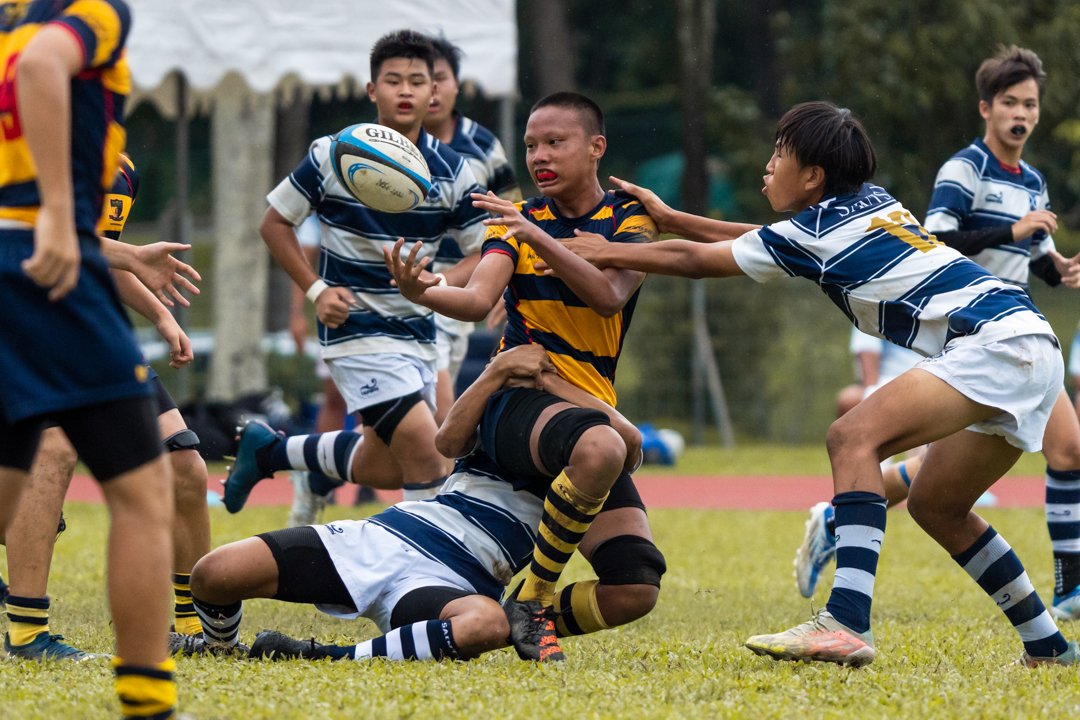Jonathan Kristianto (AC #5) makes a pass while being tackled. (Photo X © Bryan Foo/Red Sports)