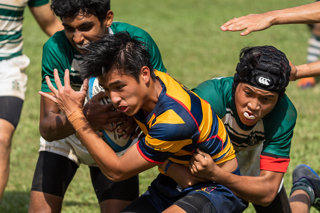 Tobias Lim (AC #14) takes contact while fending away the SJI defenders. (Photo X © Bryan Foo/Red Sports)