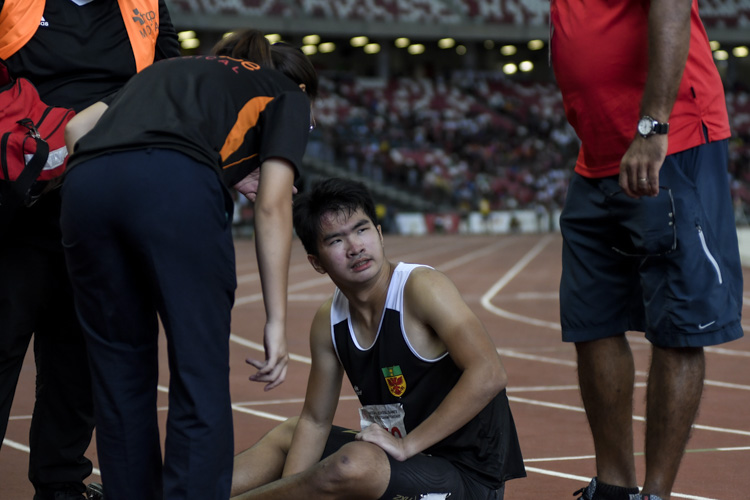 RI's Brayden Chan (#472) being attended to by medical personnel after the B Div boys' 100m final. (Photo 1 © Iman Hashim/Red Sports)