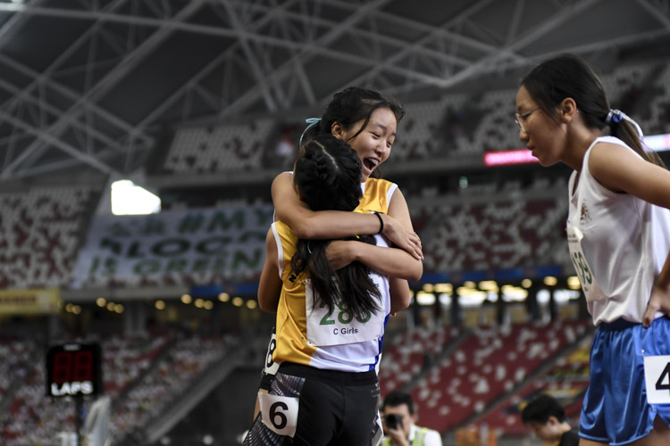 Competitors of the C Div girls' 100m final embrace after the race. (Photo 1 © Iman Hashim/Red Sports)