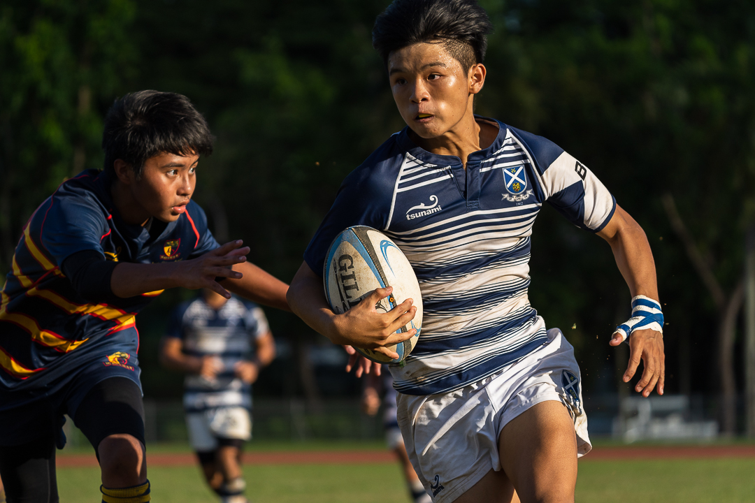 Tan Kai Wen (SA #26) carries the ball as he outpaces the opposite Barker defender down the wing. The Saints beat Barker 22-8 to advance to B Division rugby final. (Photo X © Bryan Foo/Red Sports)