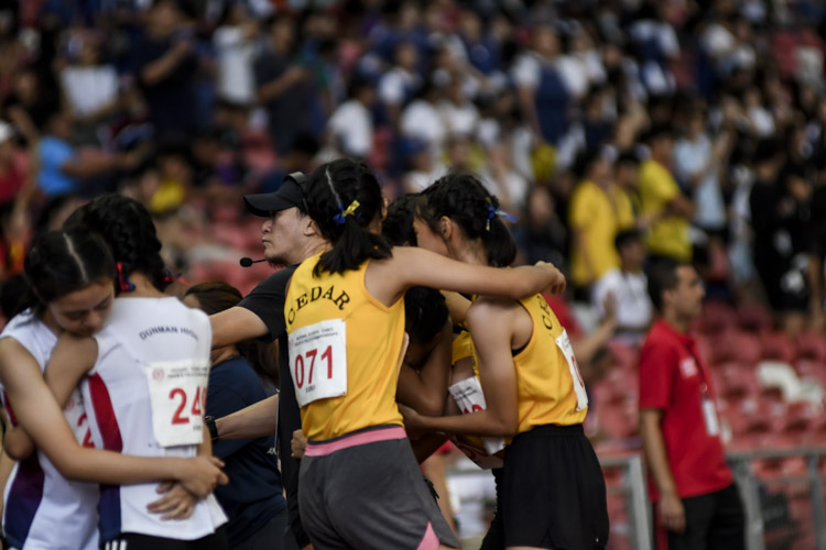 Cedar and Dunman High runners embrace after the B Div girls' 4x400m relay final. (Photo 1 © Iman Hashim/Red Sports)