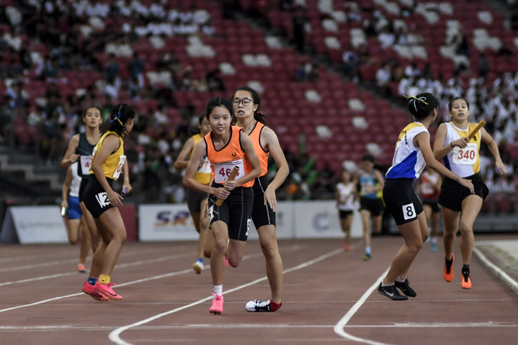 Final baton exchanges in the B Div girls' 4x400m relay final. SSP's Neo En Yu twists her ankle as she hands over the baton to anchor Victoria Chua. (Photo 1 © Iman Hashim/Red Sports)