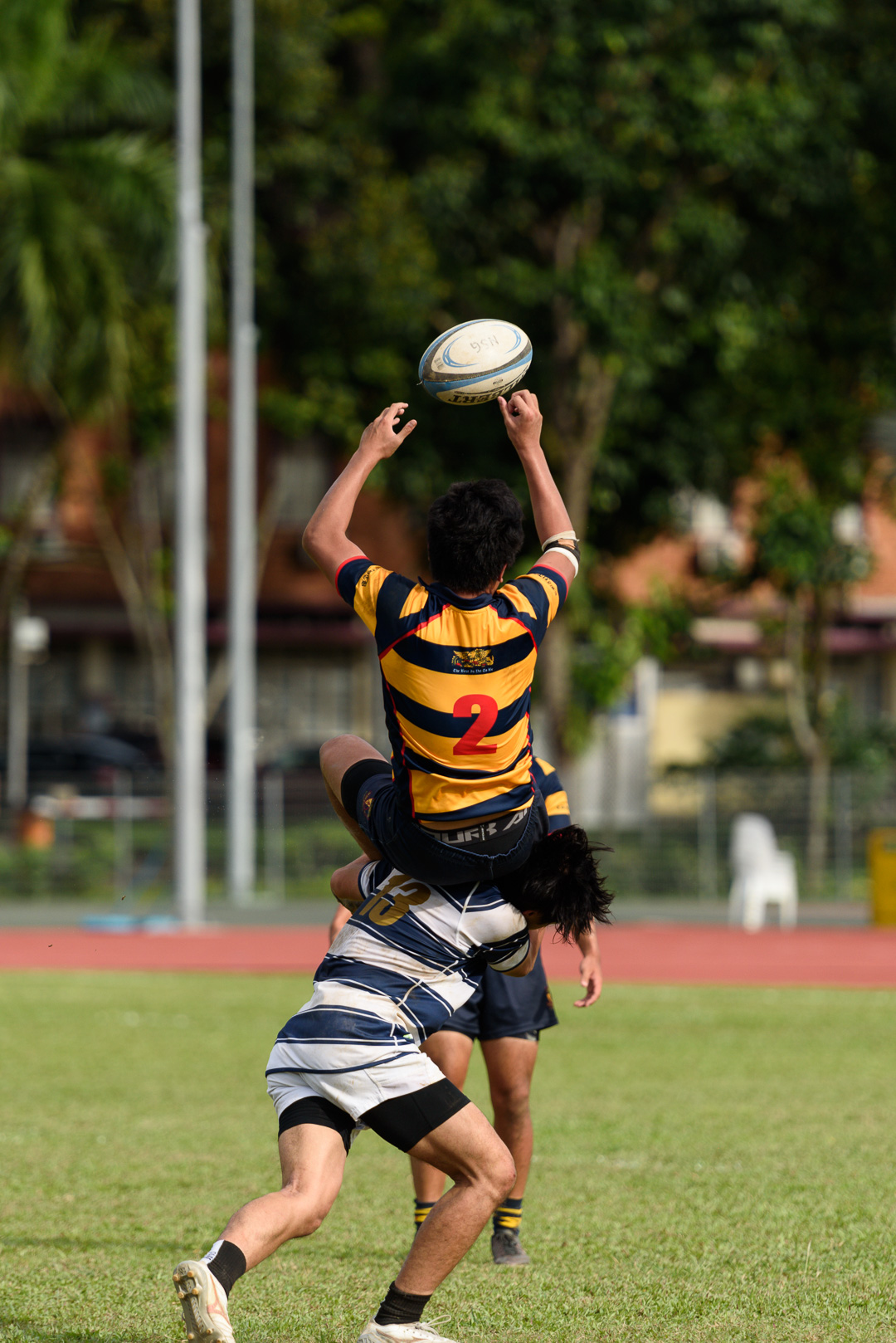 Xavier Goh (AC #2) is tackled in the air by Jeremy Tan (SA #13). (Photo 13 © Jared Chow/Red Sports)