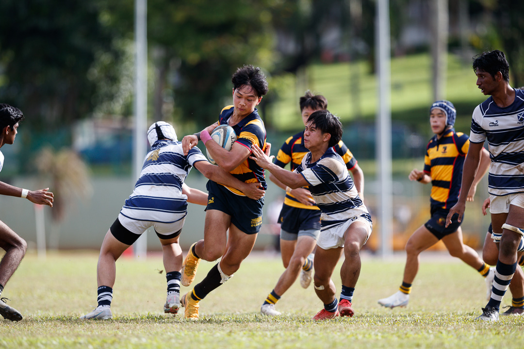 Jacob Tan (AC #5) attempts to run through the tackle of Shawn Leo (SA #4). (Photo 14 © Joash Chow/Red Sports)