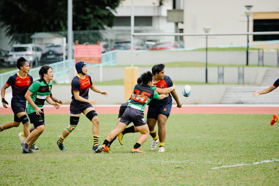 An ACJC player attempts a backhanded offload. (Photo 6 © Shenn Tan/Red Sports)