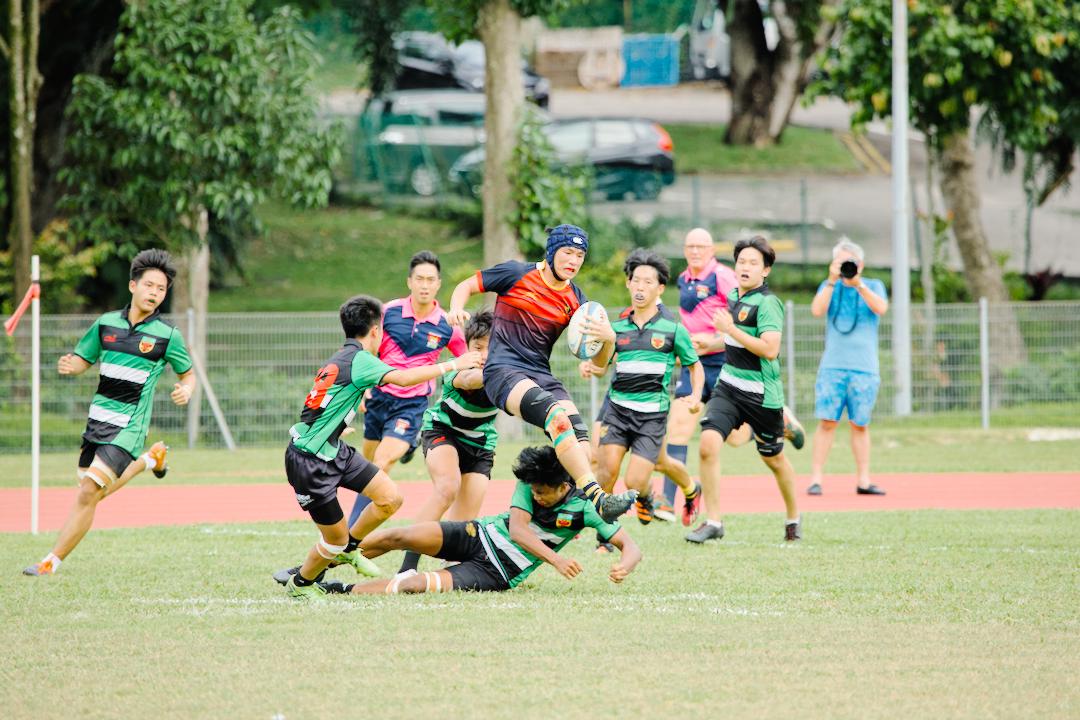 ACJC's Benjamin Yong (#6) is brought down after making a break upfield. (Photo 10 © Shenn Tan/Red Sports)